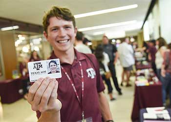 Texas A&M student holding up his Aggie Card ID.